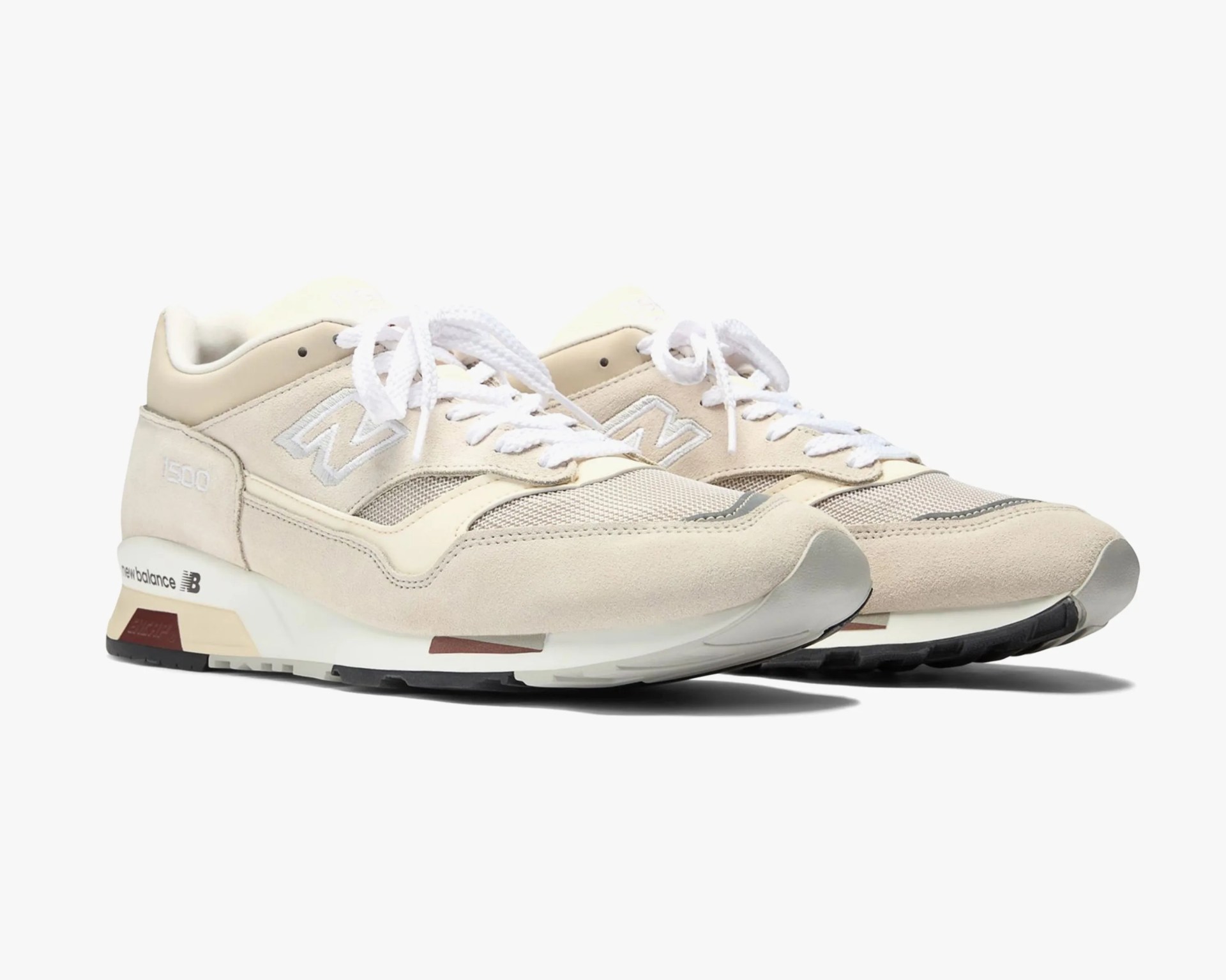 Pair of beige New Balance 1500 sneakers with white laces and mesh detailing on a white background.