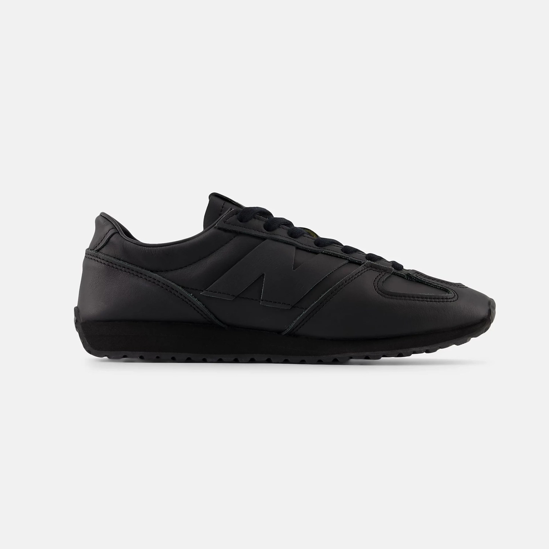 All-black leather sneaker with black laces and a subtle "N" logo on the side.