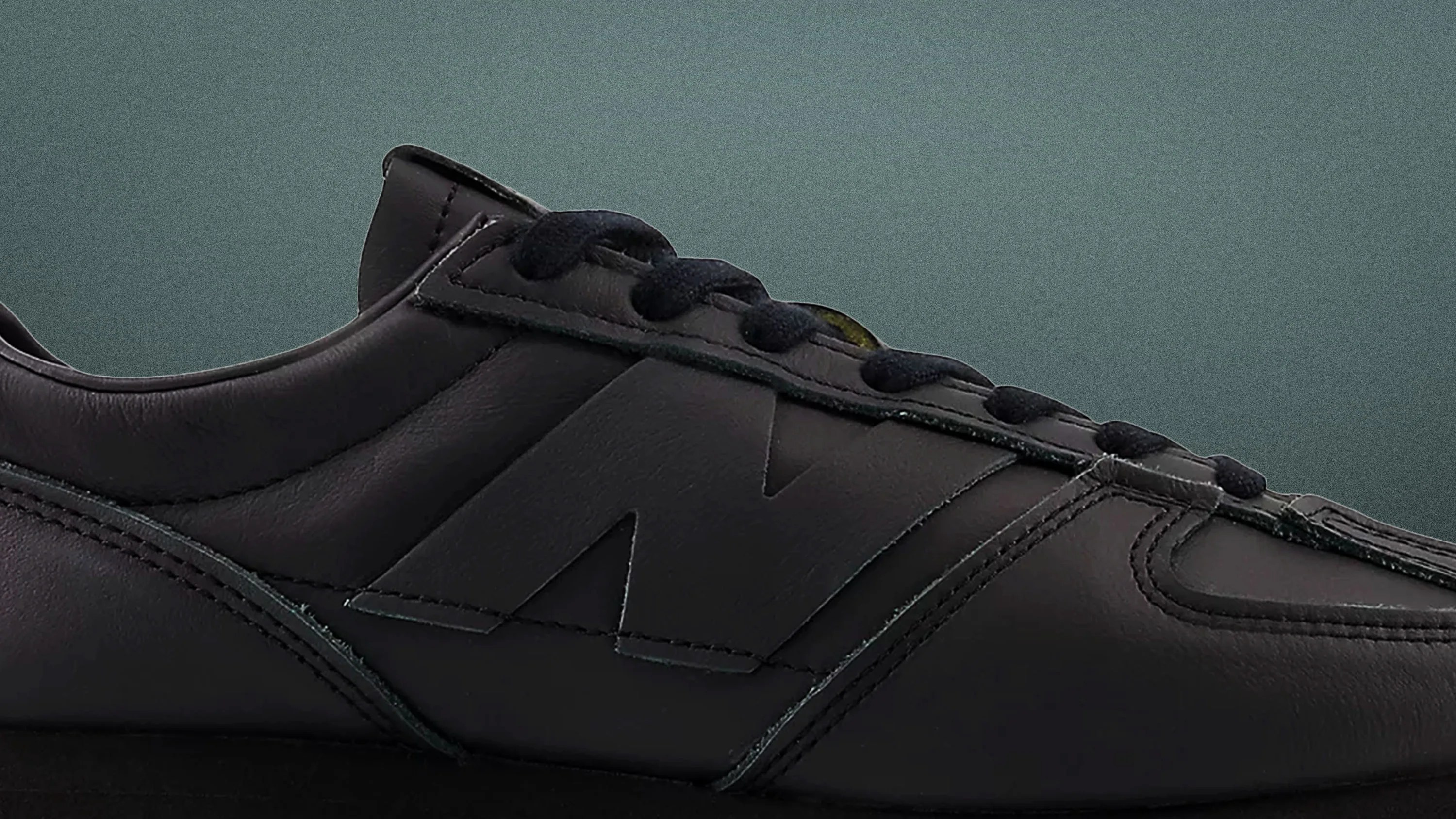 Black leather sneaker with black laces and a large embossed "N" logo on the side.