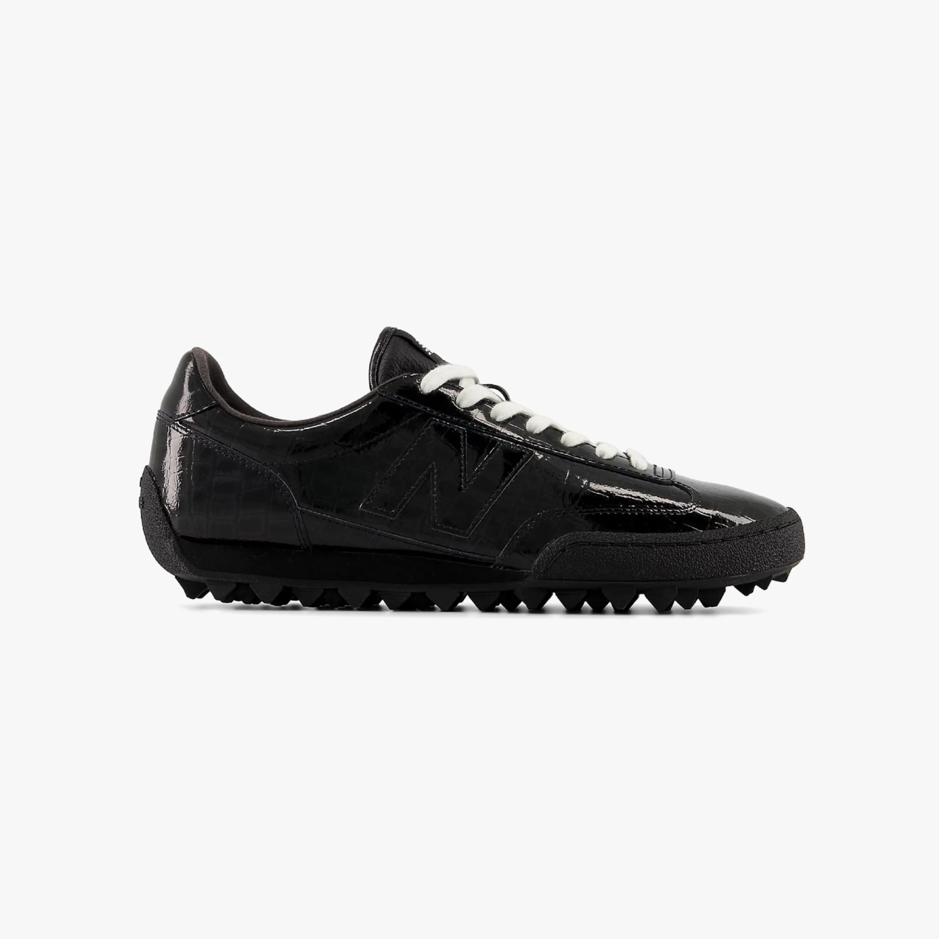Black patent leather sneaker with white laces and textured rubber sole.