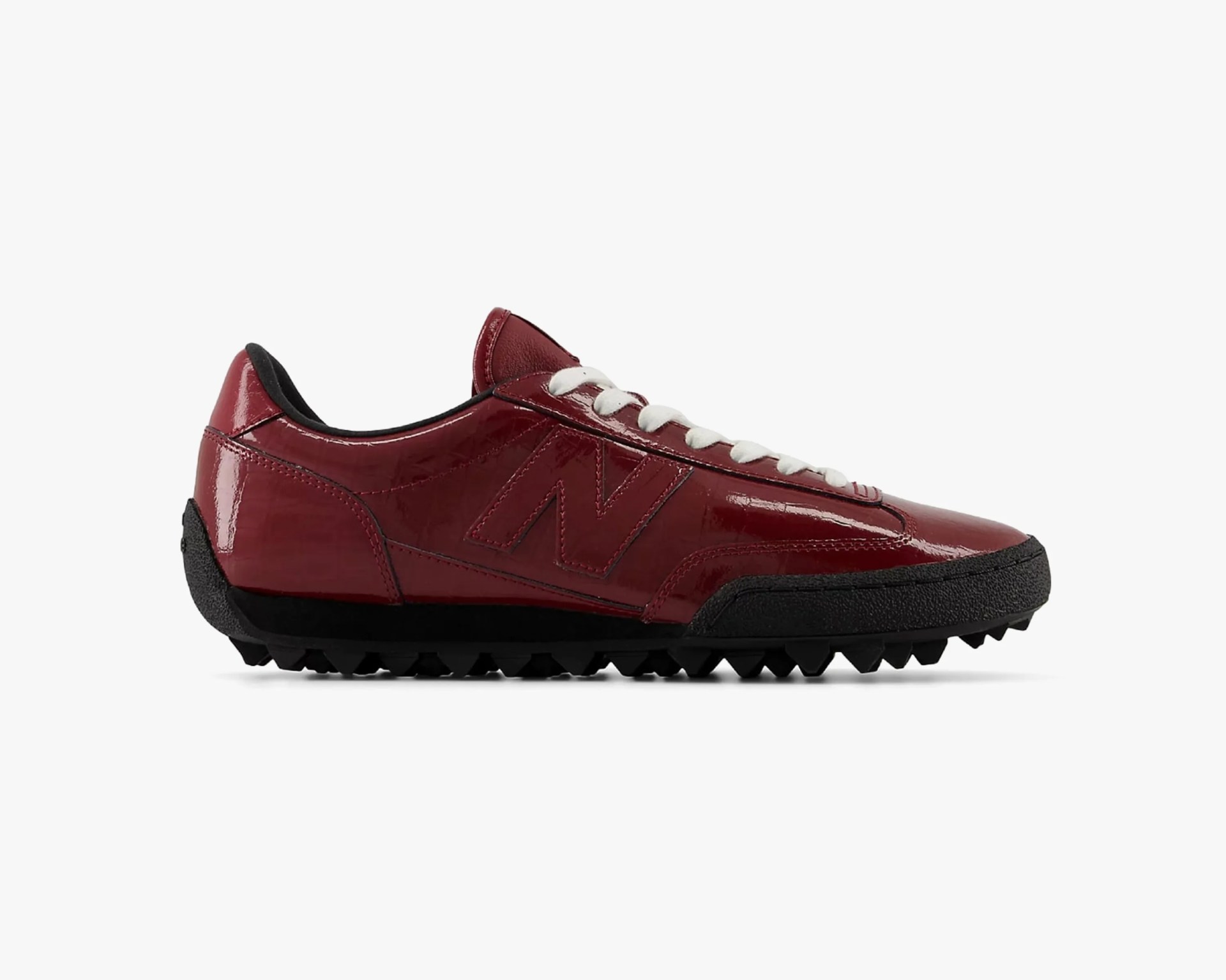 Glossy dark red sneaker with white laces and black textured sole and toe cap.