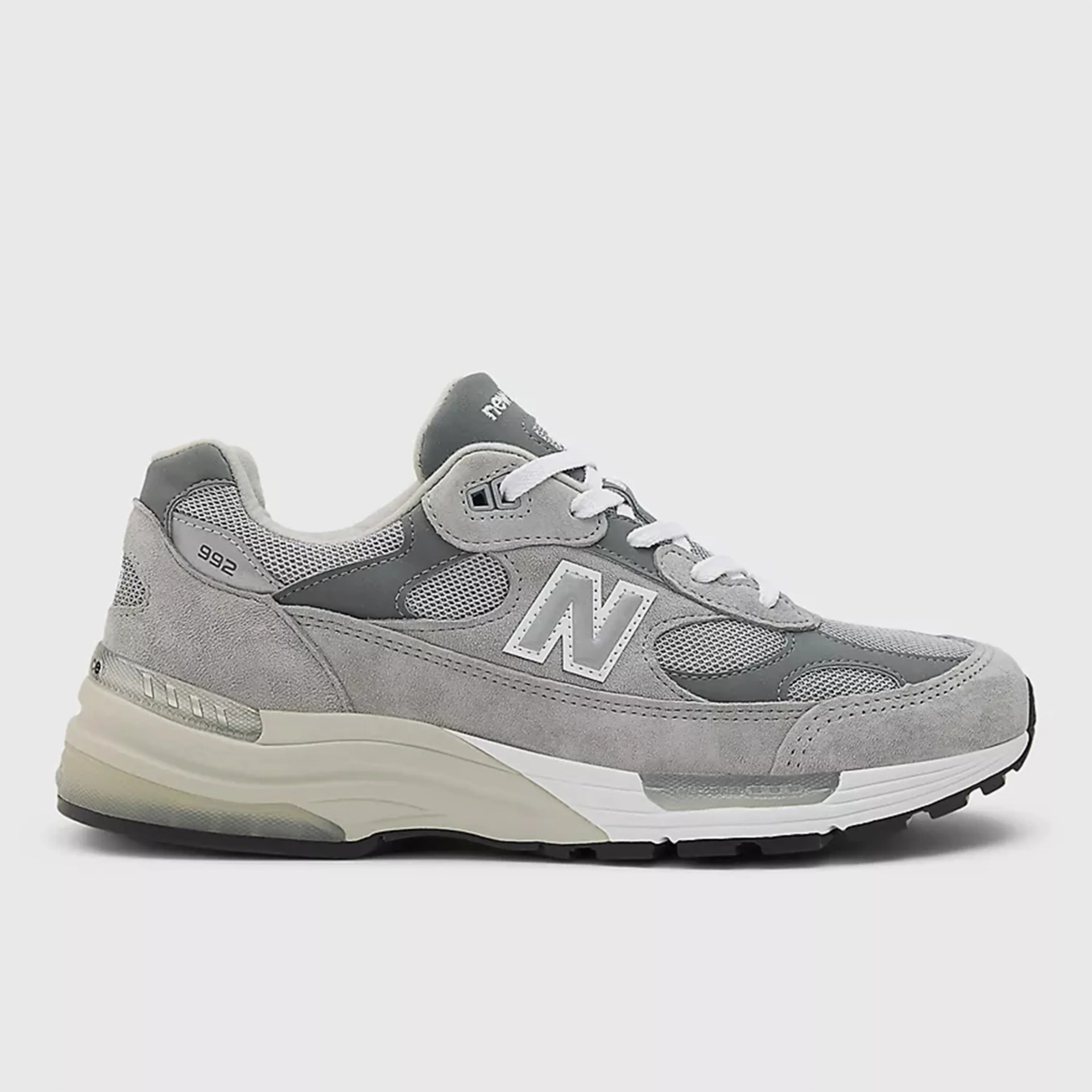 Gray New Balance 992 sneaker with suede and mesh upper, white laces, and beige and white sole.