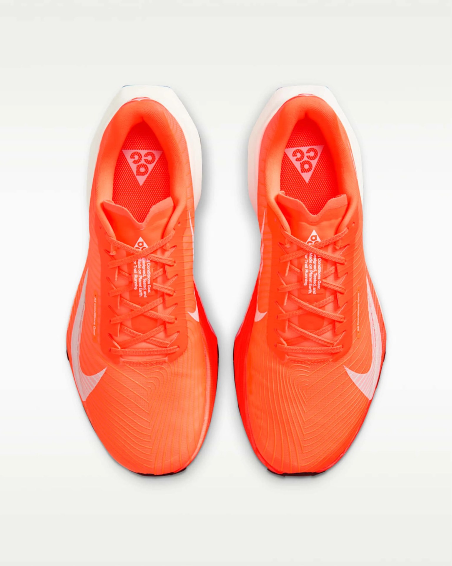 Pair of bright orange Nike running shoes with white swoosh logos, viewed from above.