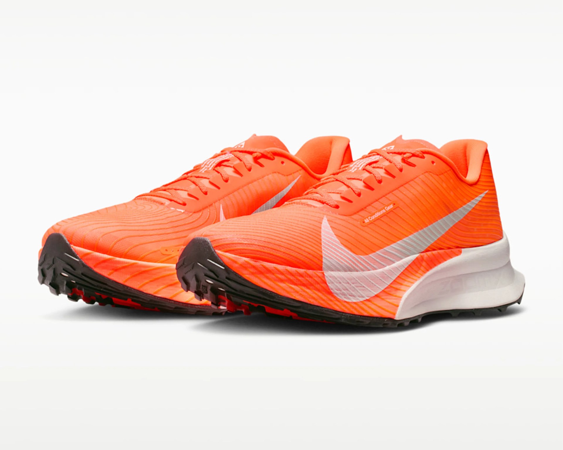 Pair of bright orange Nike running shoes with white swoosh logos and black soles on a white background.