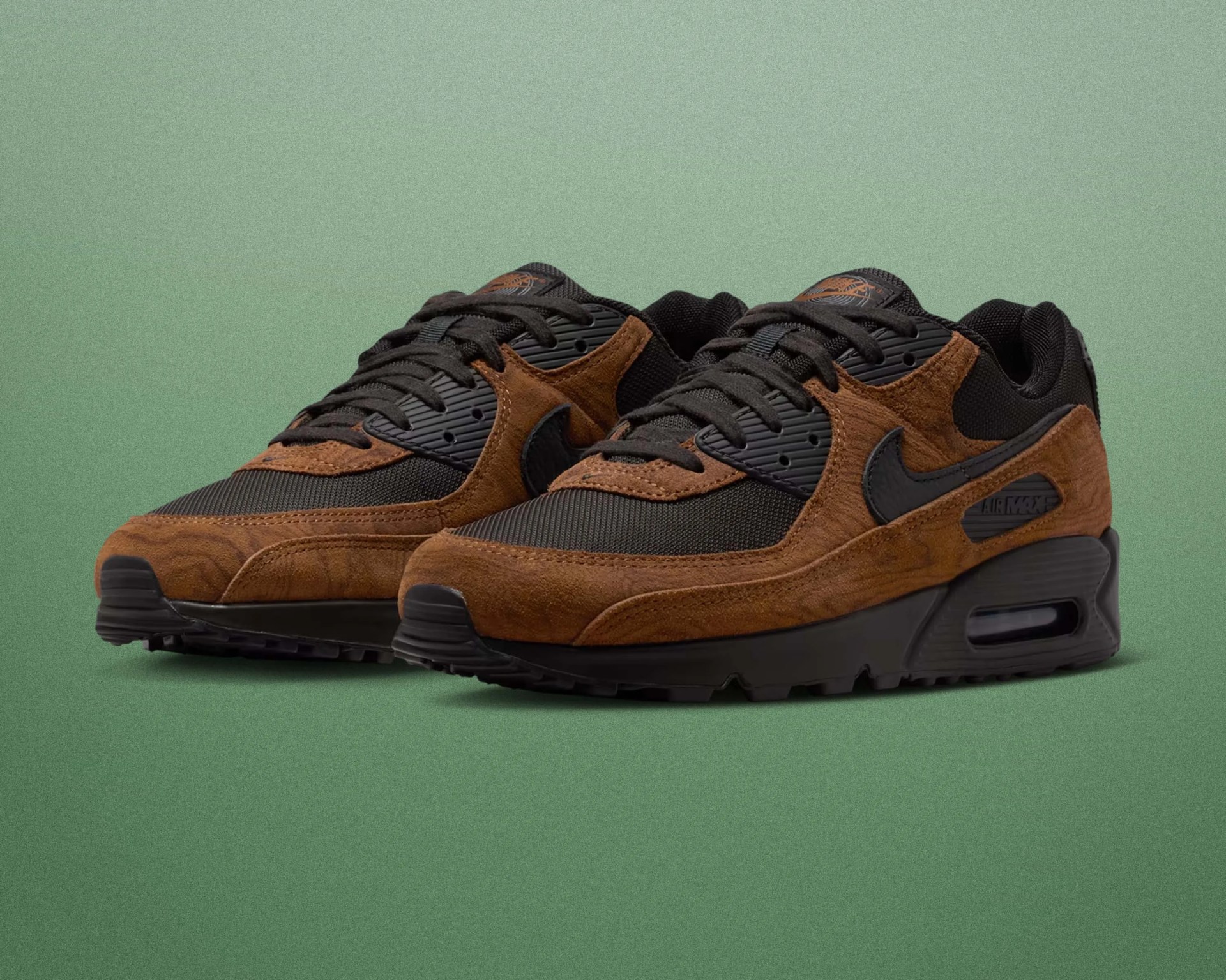 Pair of brown suede and black mesh Nike Air Max sneakers on a green gradient background.