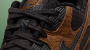 Close-up of black and brown Nike sneaker with suede texture and black laces.