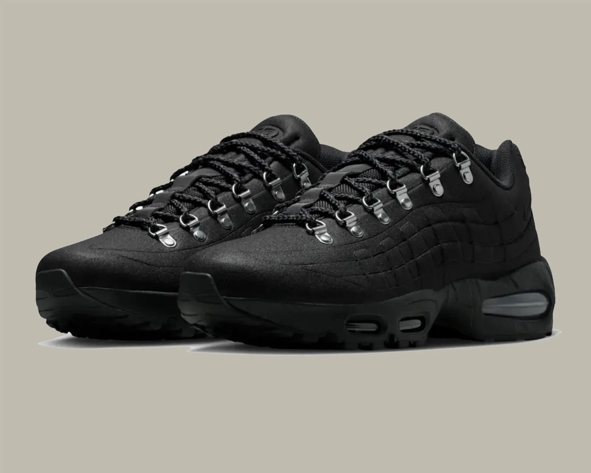 Pair of black athletic sneakers with metal eyelets and visible air cushioning in the sole.