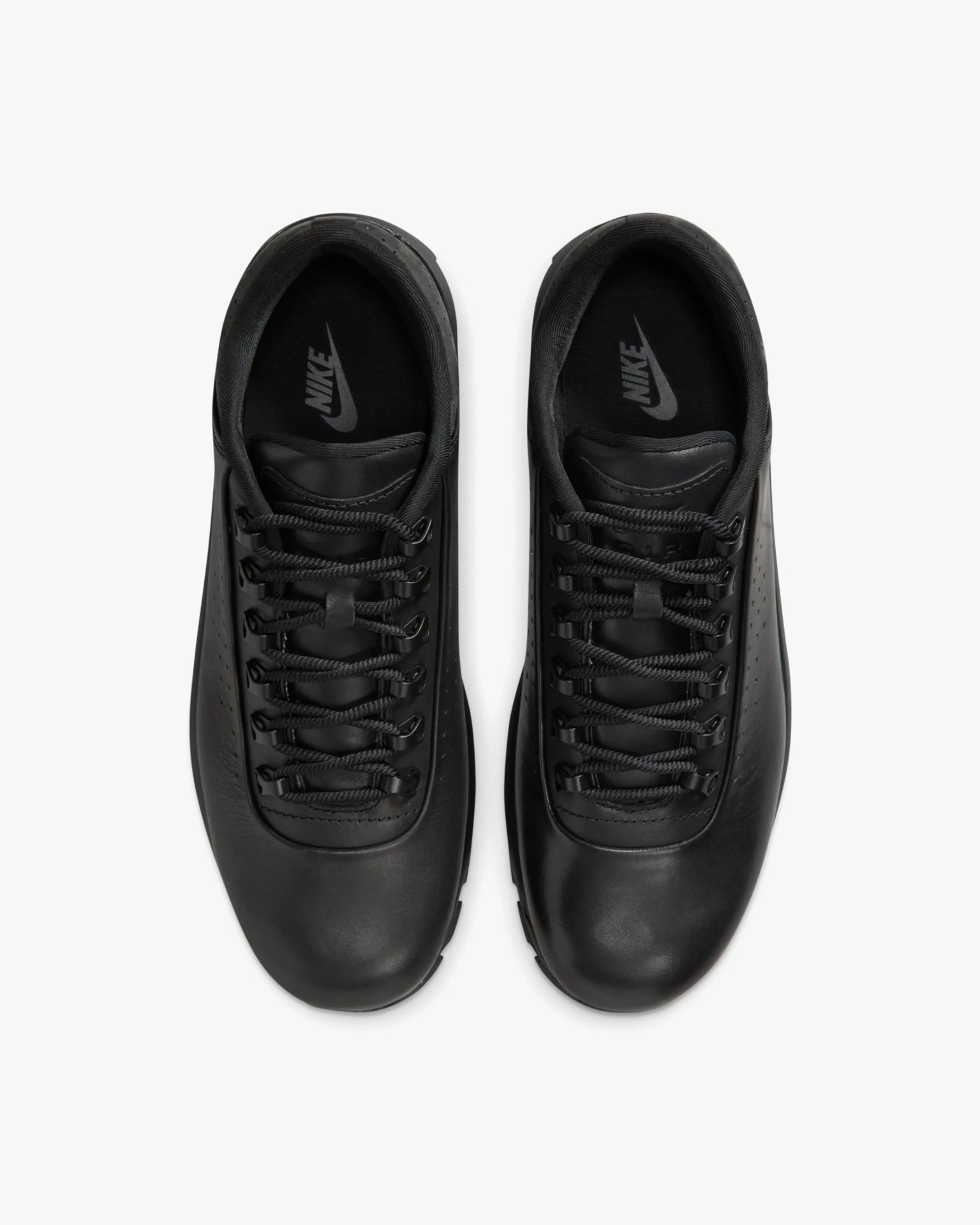 Pair of black Nike leather sneakers with black laces viewed from above on a white background.