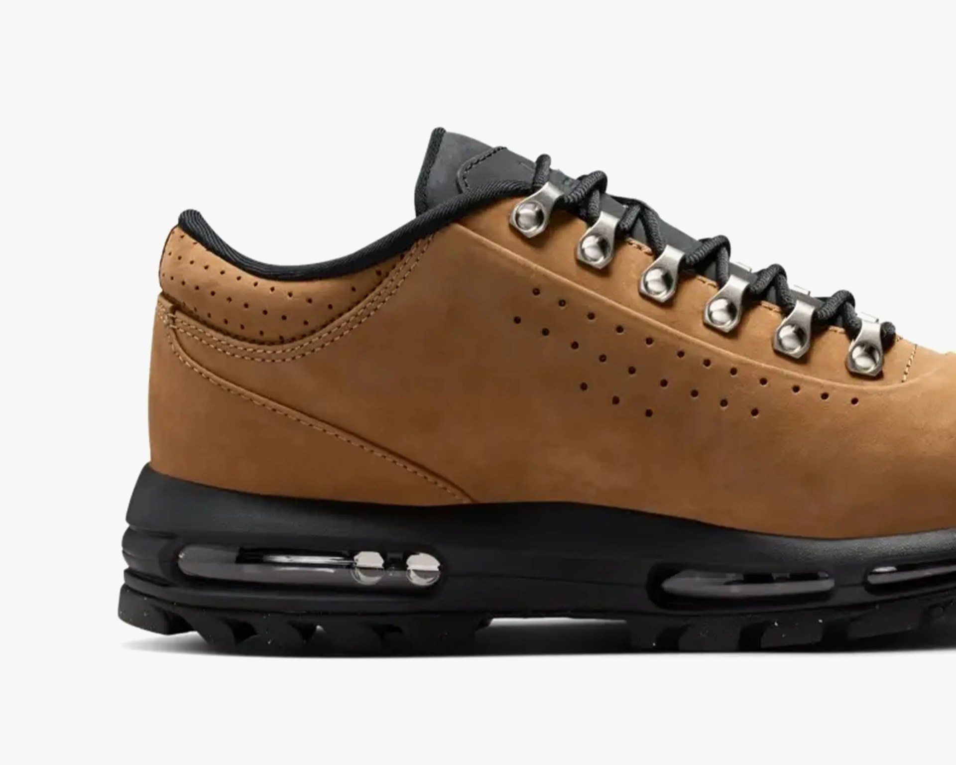 Brown leather sneaker with black sole and metal eyelets for laces.