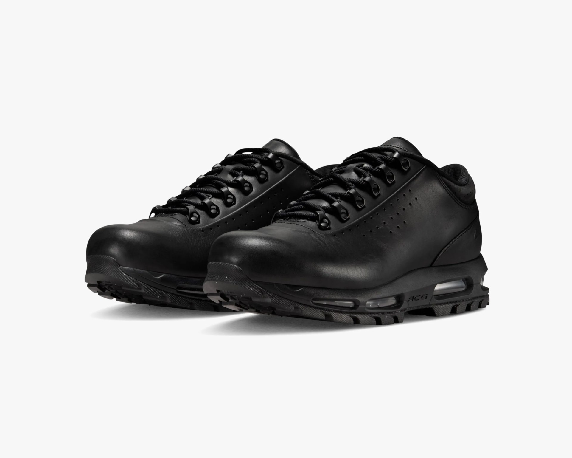 Pair of black leather hiking shoes with thick soles and visible air cushioning units.
