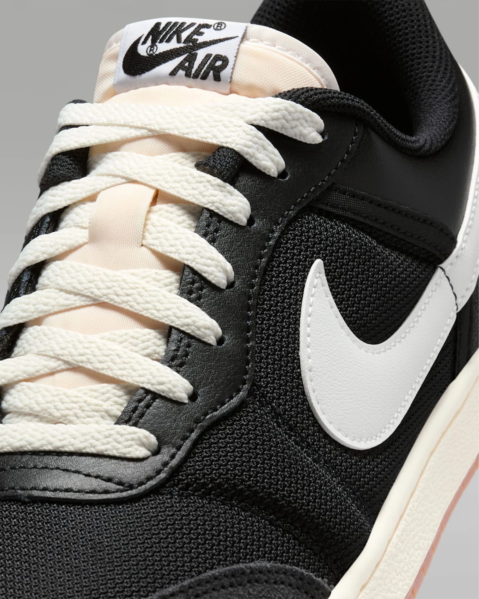 Close-up of a black Nike Air sneaker with white laces and a white Nike swoosh logo.