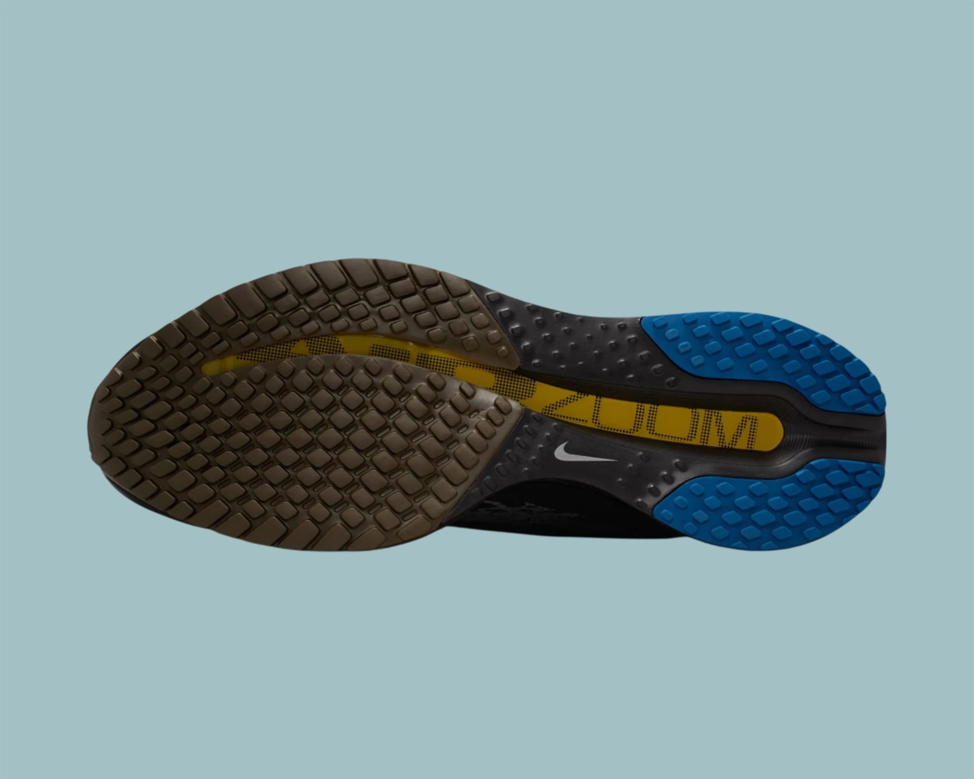Sole of a Nike running shoe with black, blue, and yellow tread on a light blue background.