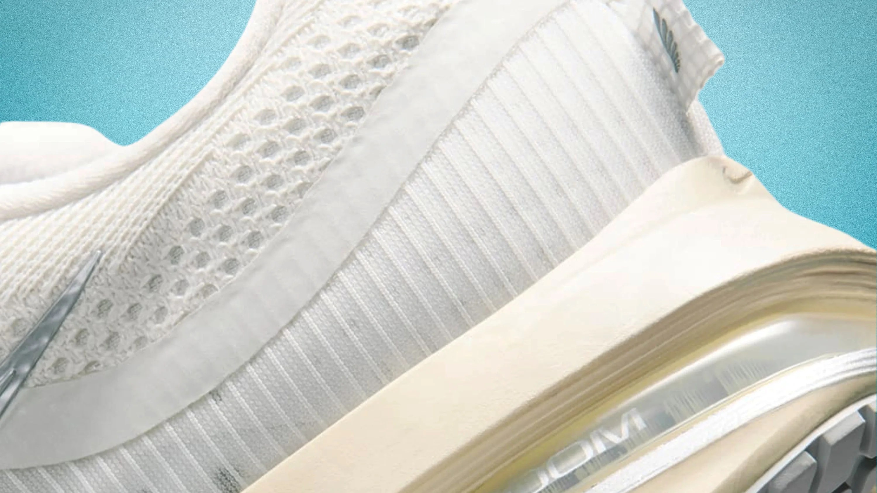 Close-up of a white Nike sneaker showing mesh fabric, ribbed textile, and a visible air cushion sole against a blue background.