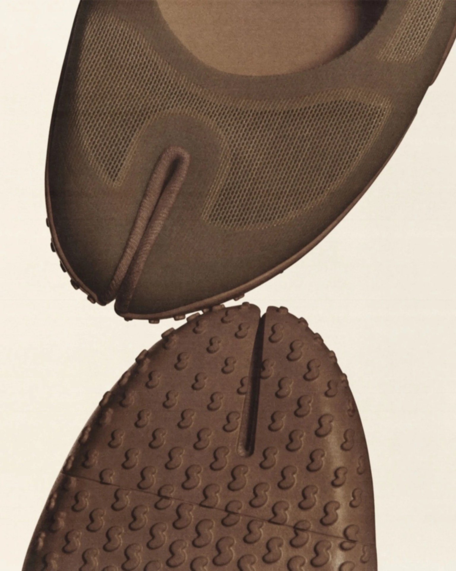 Close-up of brown split-toe shoes showing textured mesh upper and rubber sole with small circular grips.