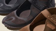 Close-up of three Nike slip-on shoes in black, dark brown, and light brown with mesh panels and a strap across the top.