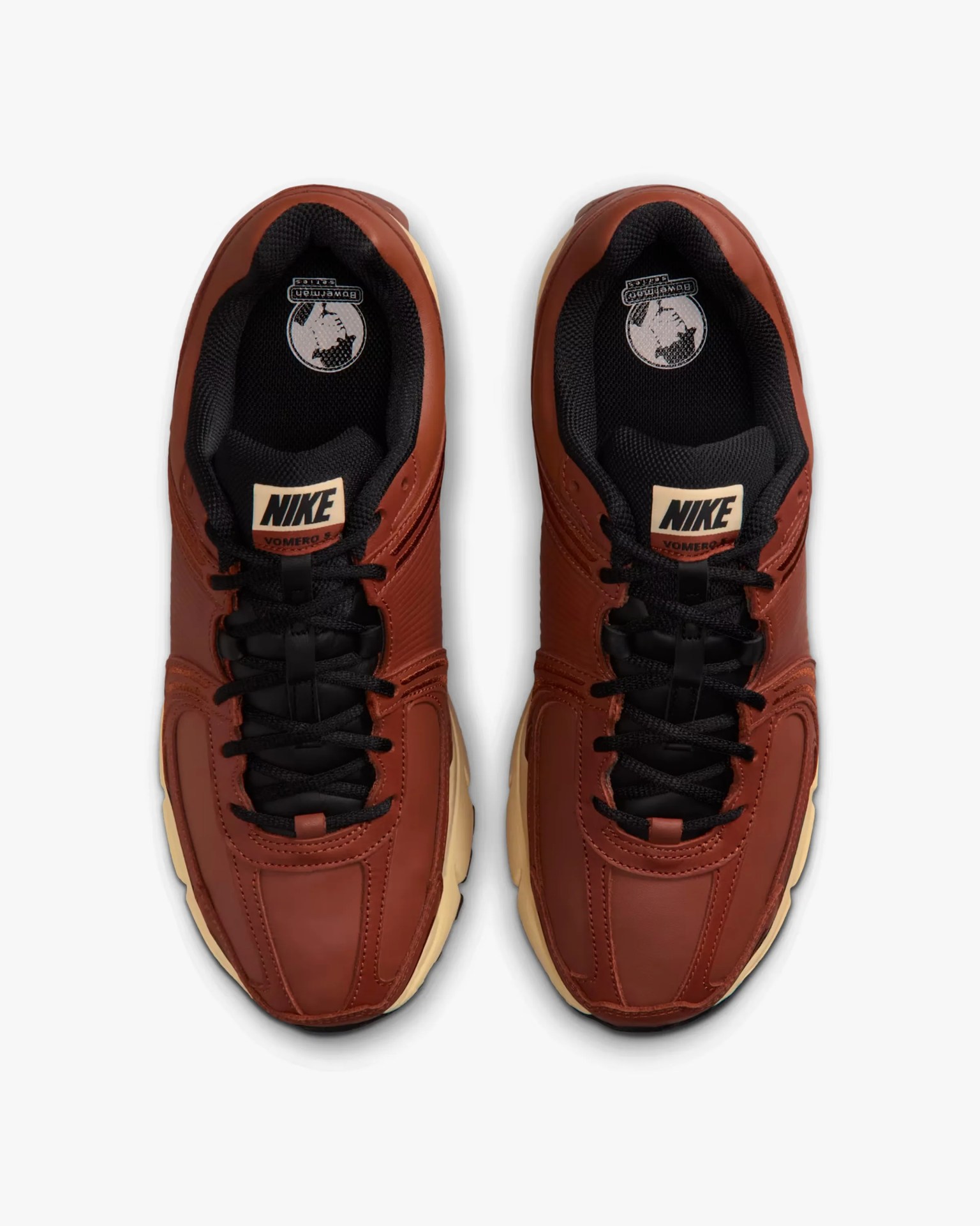 Pair of brown Nike Vomero 5 sneakers with black laces and beige soles viewed from above.