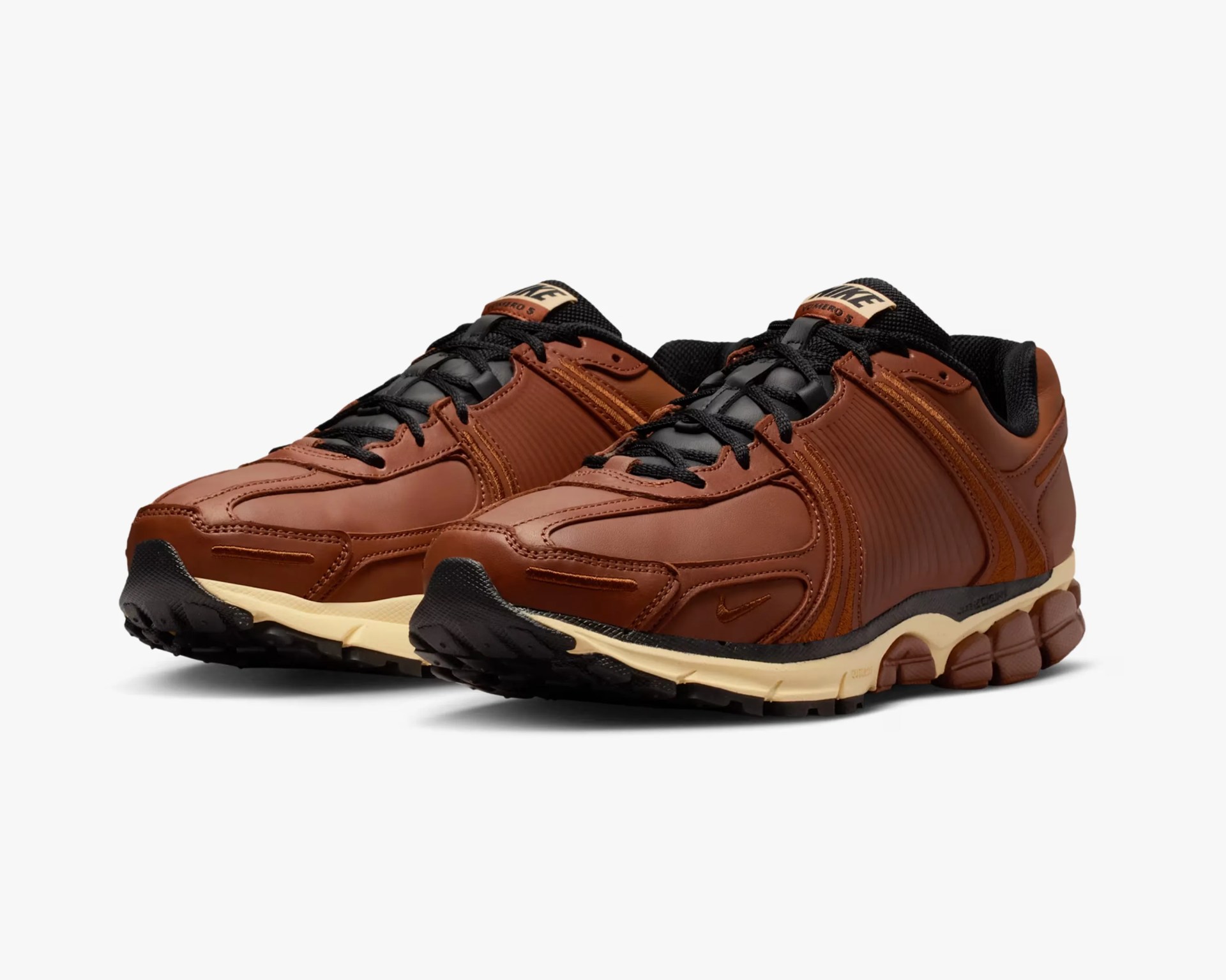 Pair of brown leather Nike sneakers with black laces and beige soles on a white background.