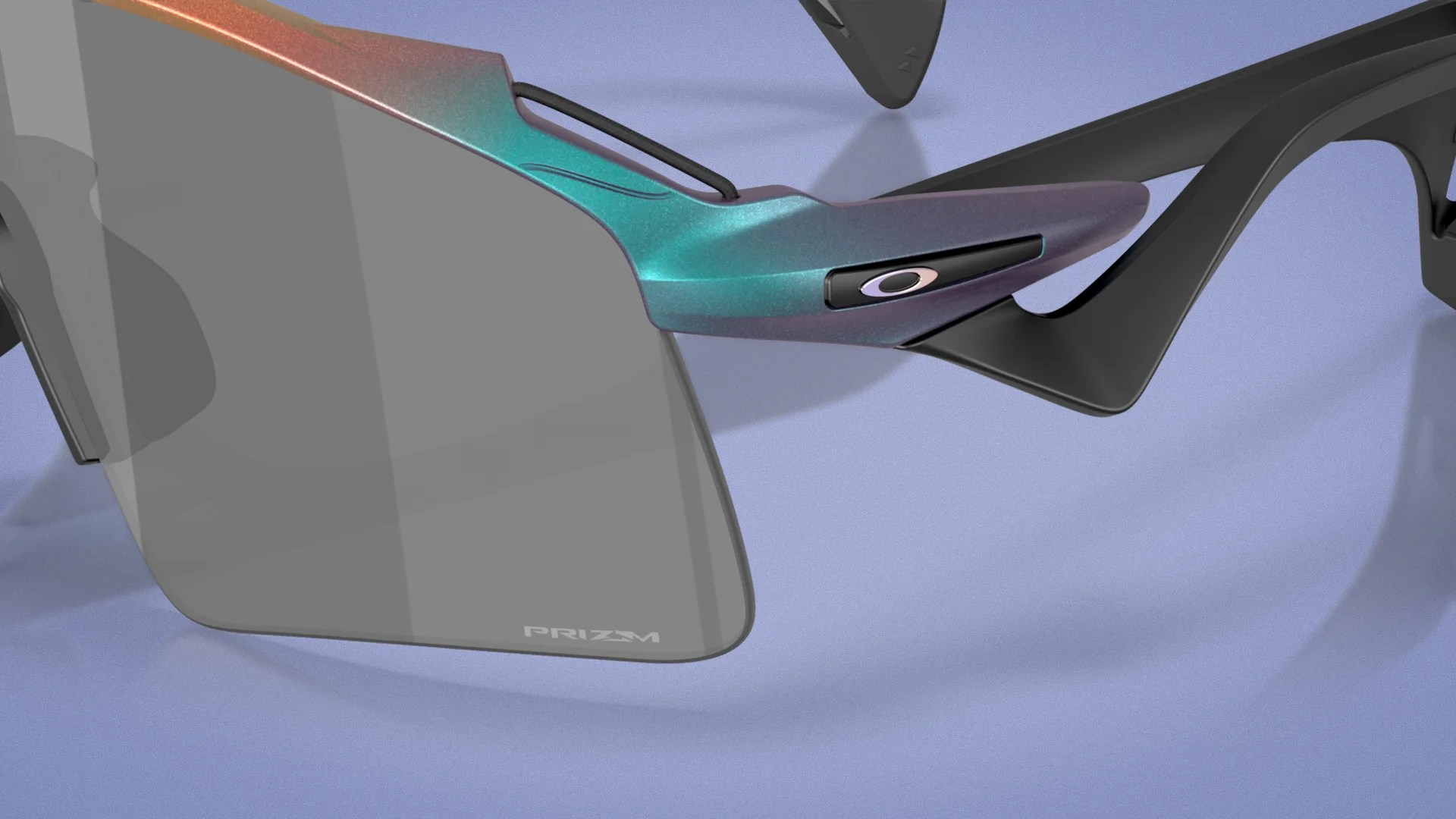 Close-up of sunglasses with iridescent teal and purple frame, black arms, and gray lenses labeled "PRIZM.