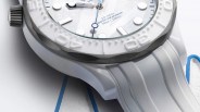 Close-up of a white dive watch with textured bezel, blue second hand, and white rubber strap.
