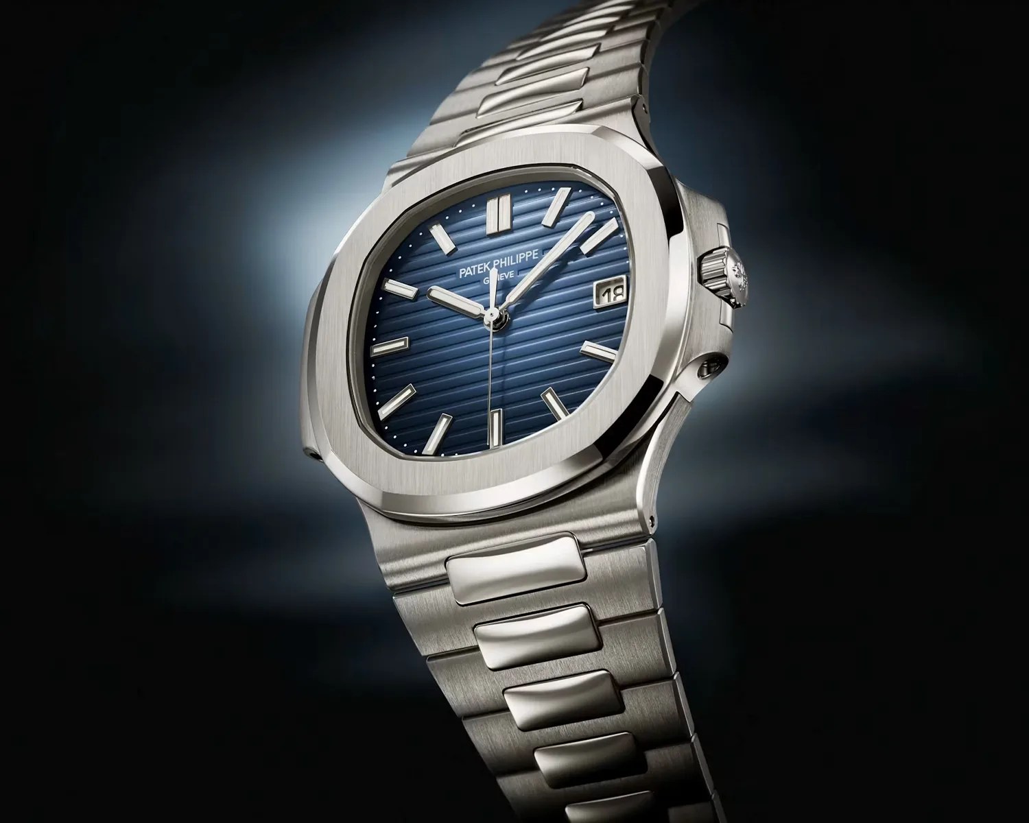 Silver stainless steel Patek Philippe wristwatch with a blue textured dial and date window.