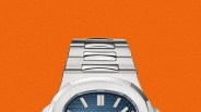 Stainless steel wristwatch with a blue textured dial and silver hour markers on an orange background.