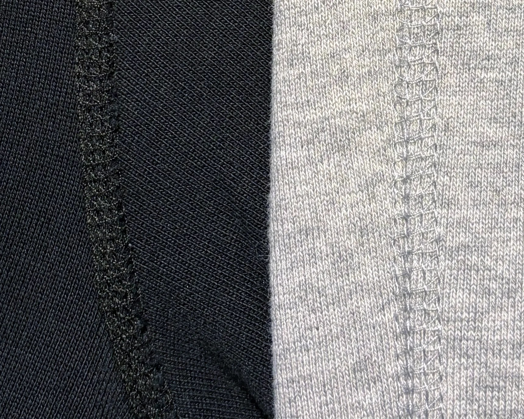 Close-up of black and gray knit fabric with visible vertical stitching seams.