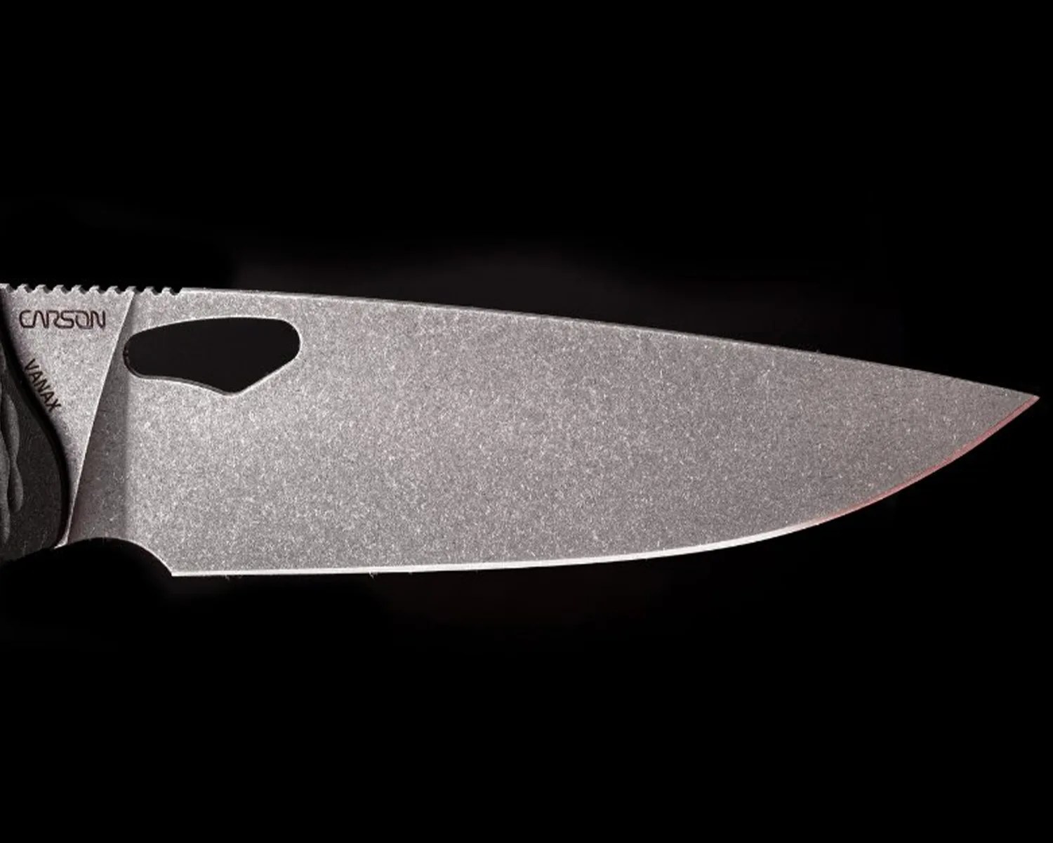 Stonewashed gray knife blade with a thumb hole and "CARSON" and "VANAX" markings on a black background.