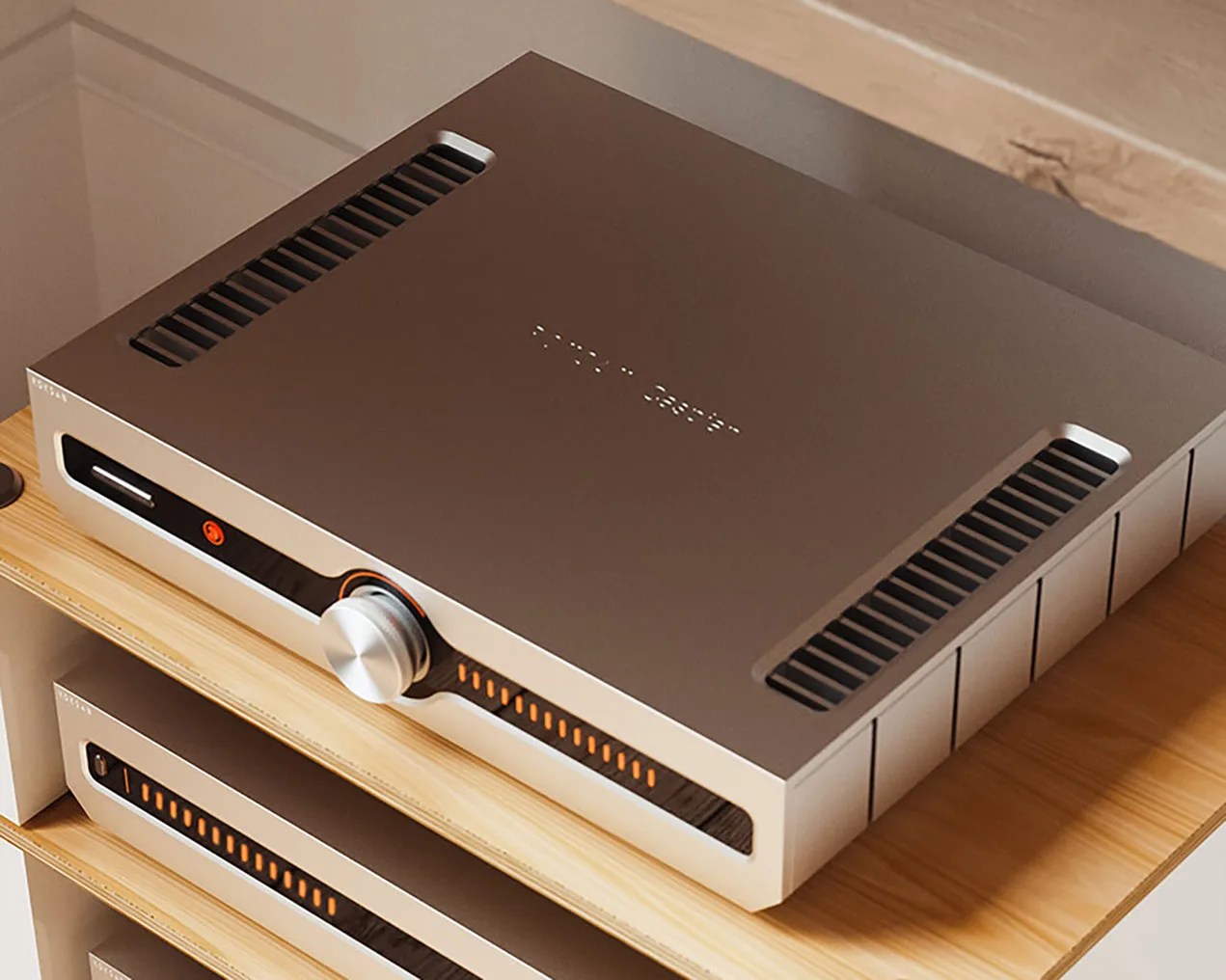 Silver and black audio amplifier with orange LED indicators and a large central knob on a wooden shelf.