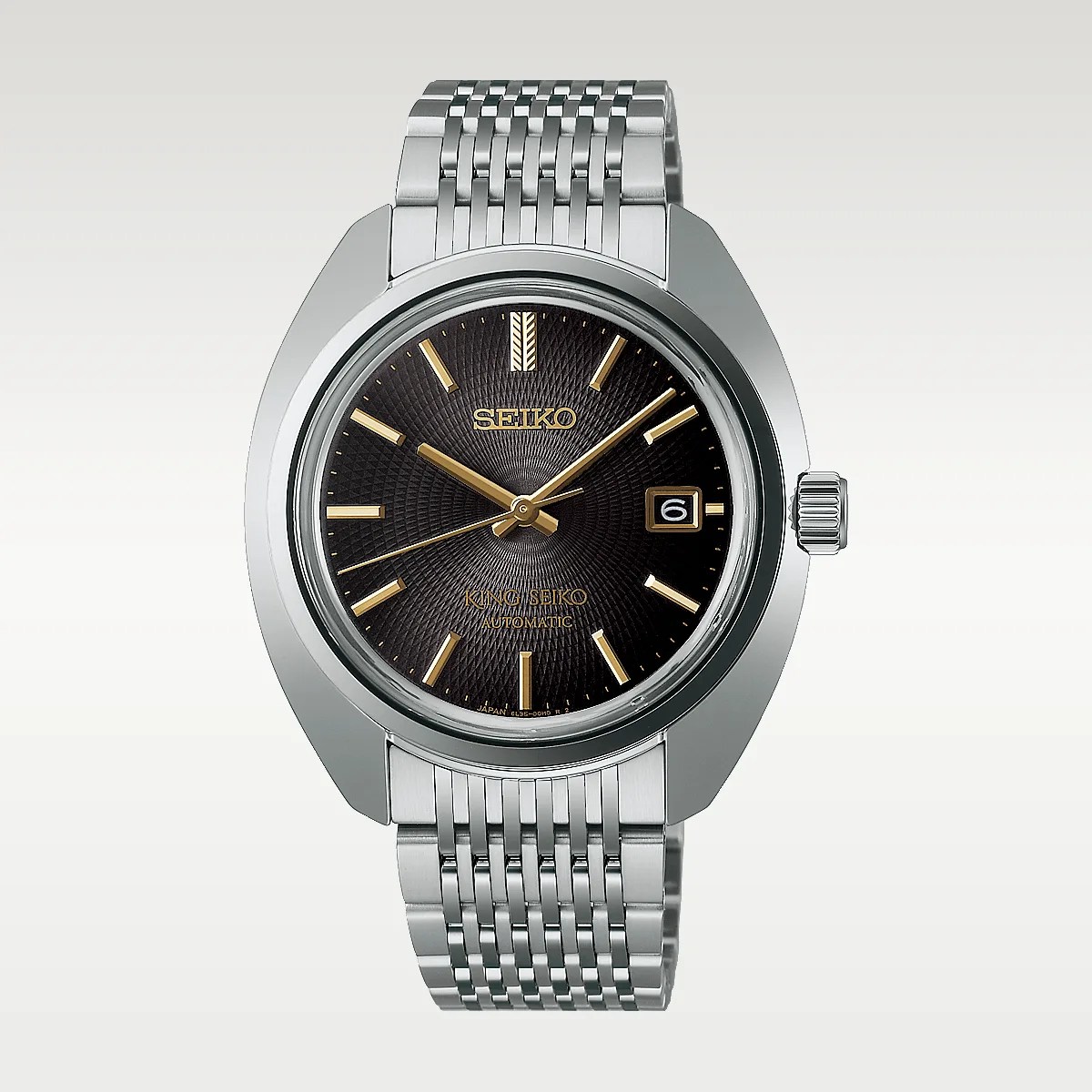 Silver stainless steel Seiko wristwatch with black textured dial, gold hour markers, and date display at 3 o'clock.