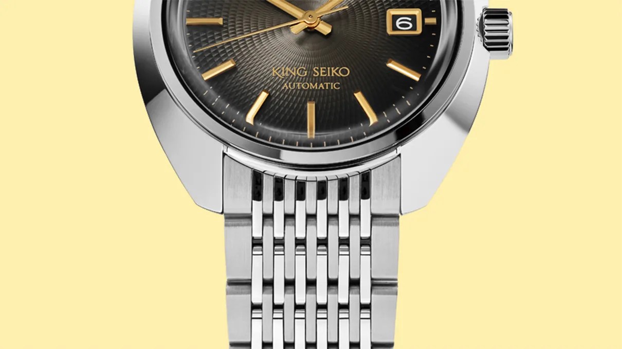 Close-up of a King Seiko automatic watch with a black textured dial, gold markers, and a stainless steel bracelet.