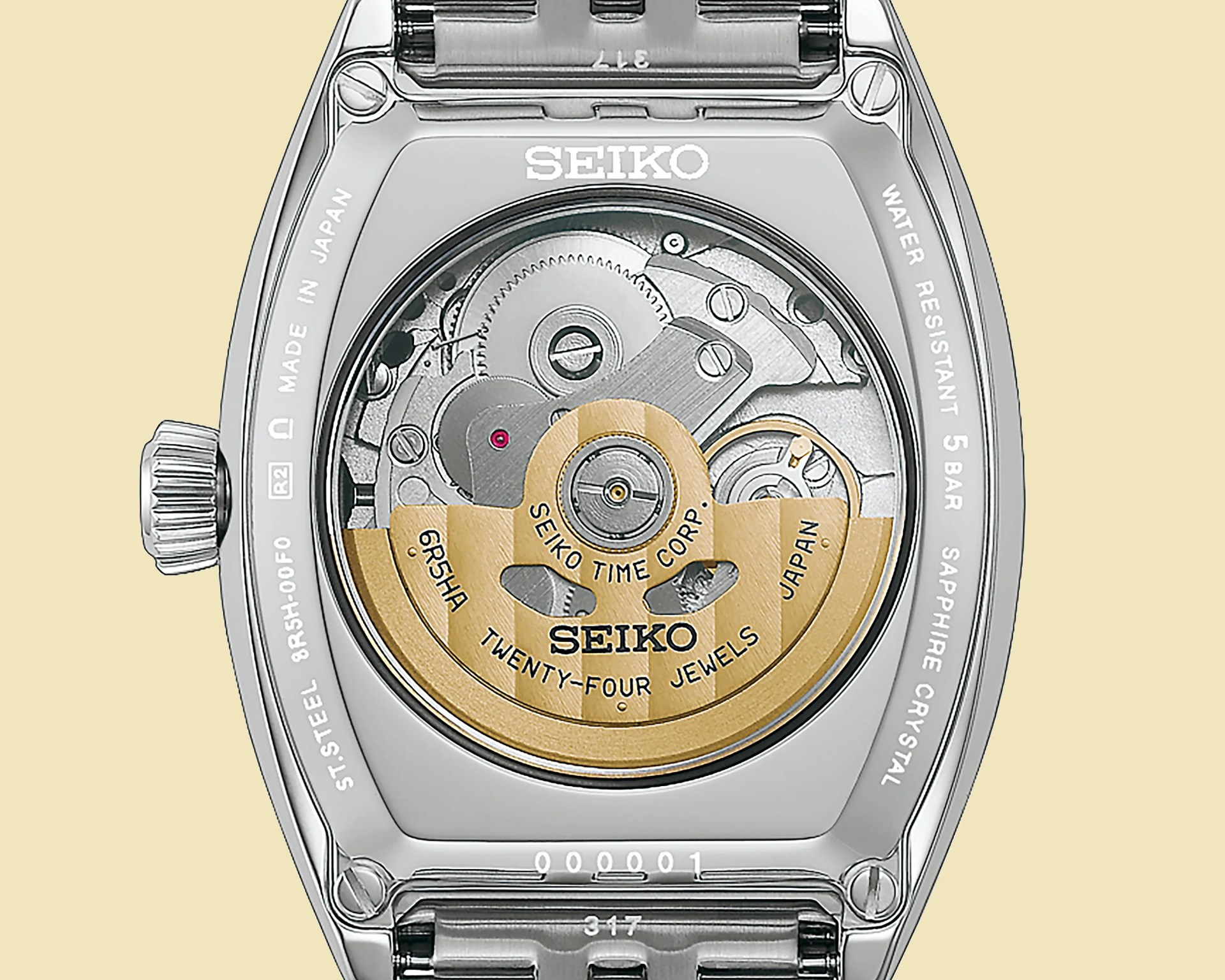 Back of a Seiko watch showing the automatic movement with gold rotor and stainless steel case.
