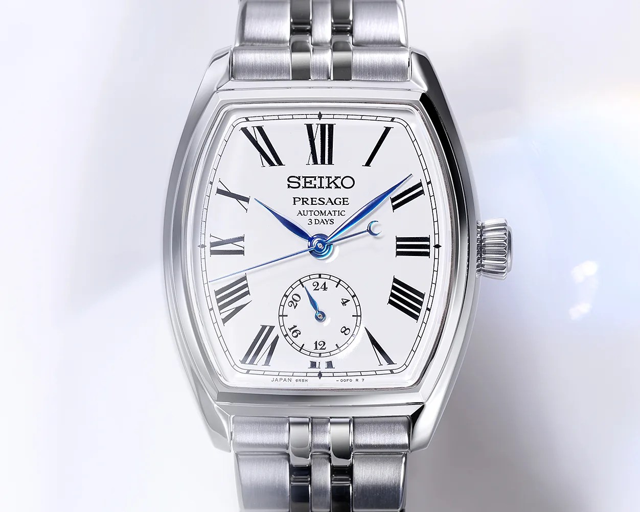 Silver Seiko Presage automatic wristwatch with white dial, black Roman numerals, and blue hands.