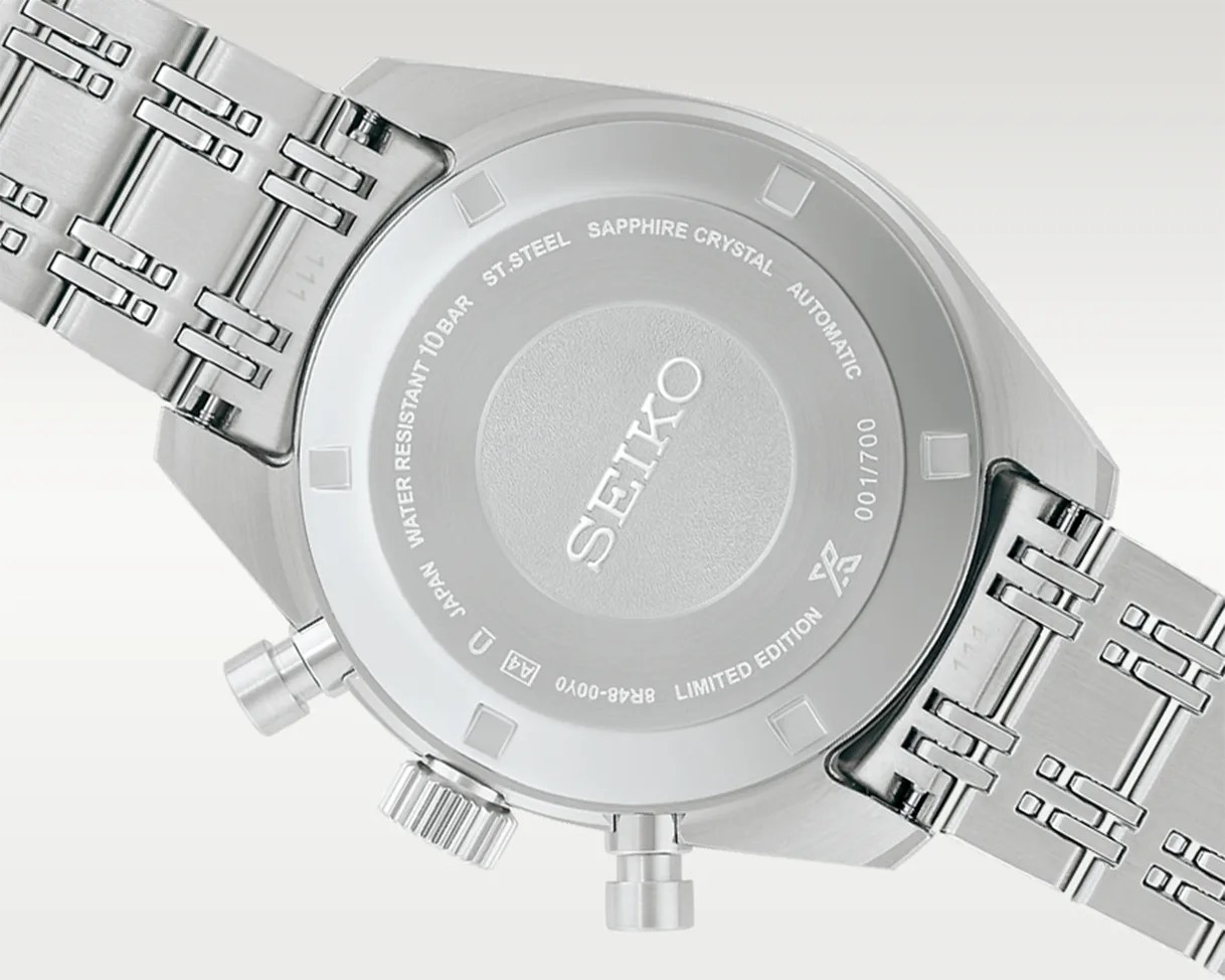 Back of a silver Seiko stainless steel watch with engraved text and a metal link bracelet.