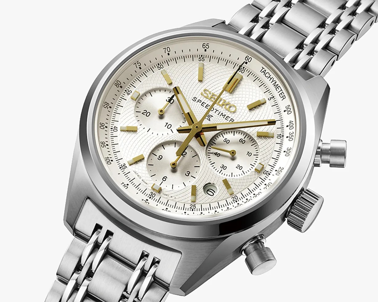 Silver Seiko Speedtimer chronograph watch with white textured dial, gold-tone hands and markers, and stainless steel bracelet.