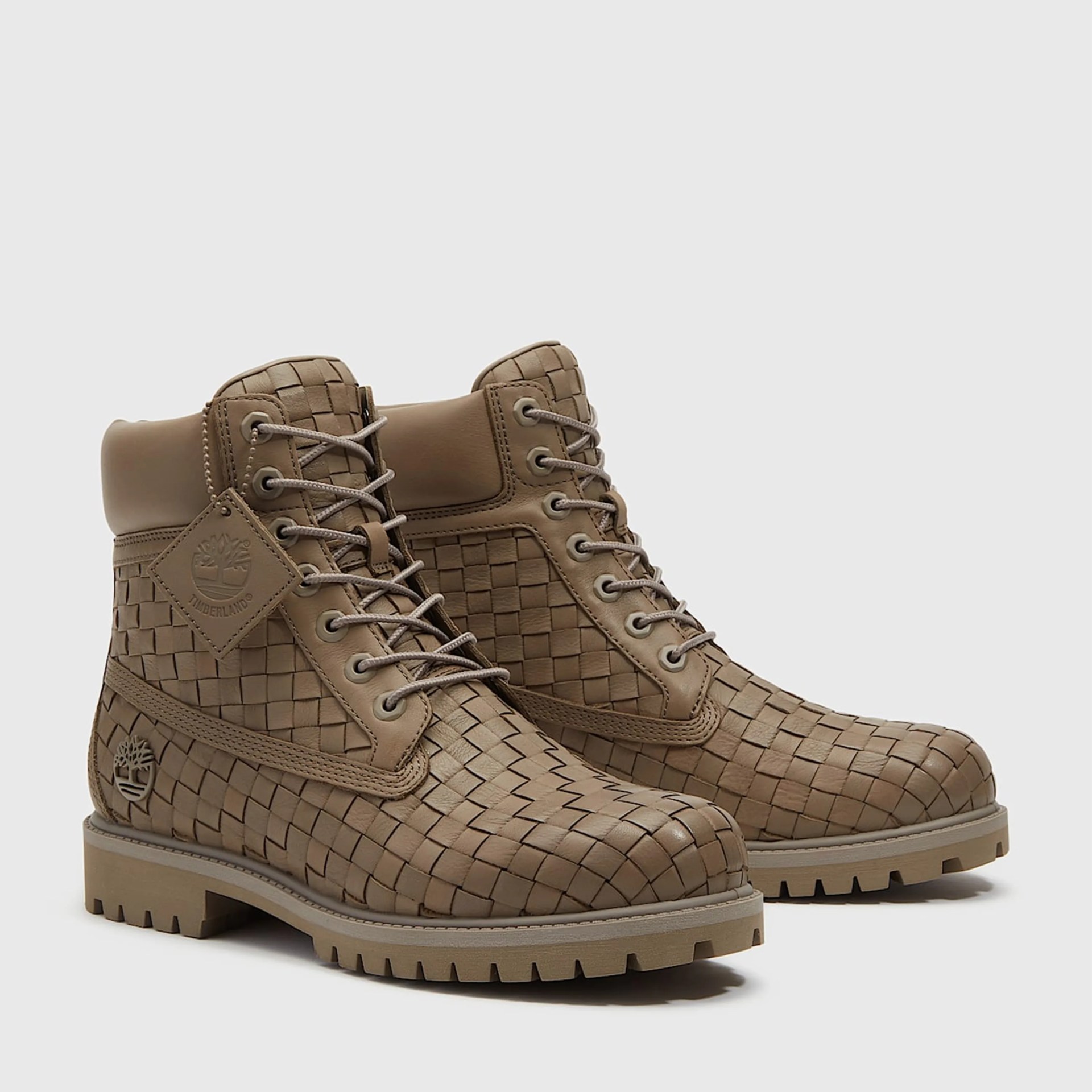 Pair of tan woven leather Timberland boots with padded collars and rubber lug soles.