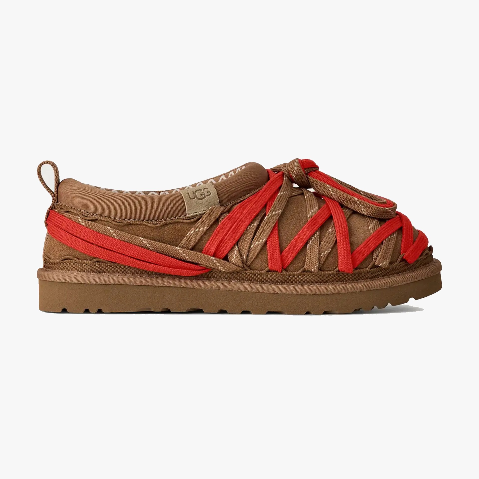 Brown suede UGG shoe with red and brown crisscross straps and a flat sole.