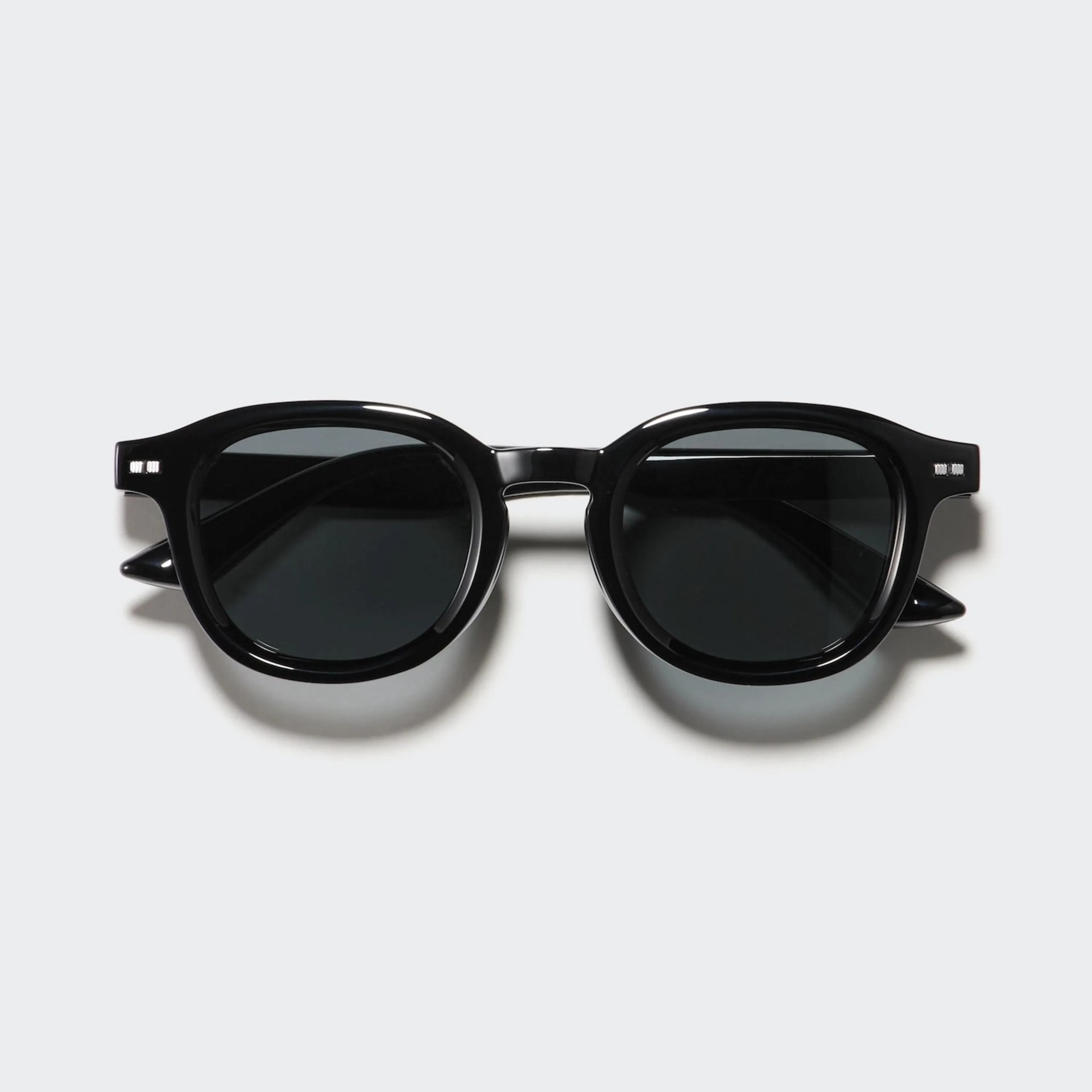 Black acetate sunglasses with round dark lenses and small silver accents on the temples.