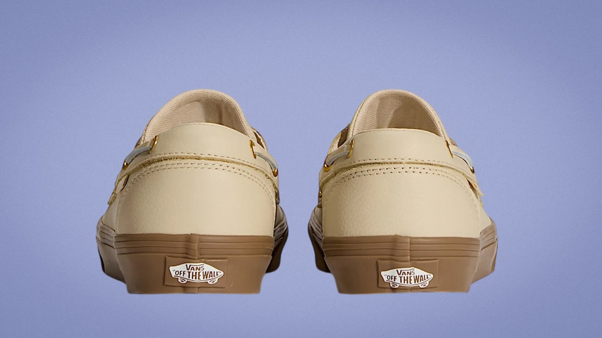 Pair of beige Vans sneakers with brown soles shown from the back against a purple background.