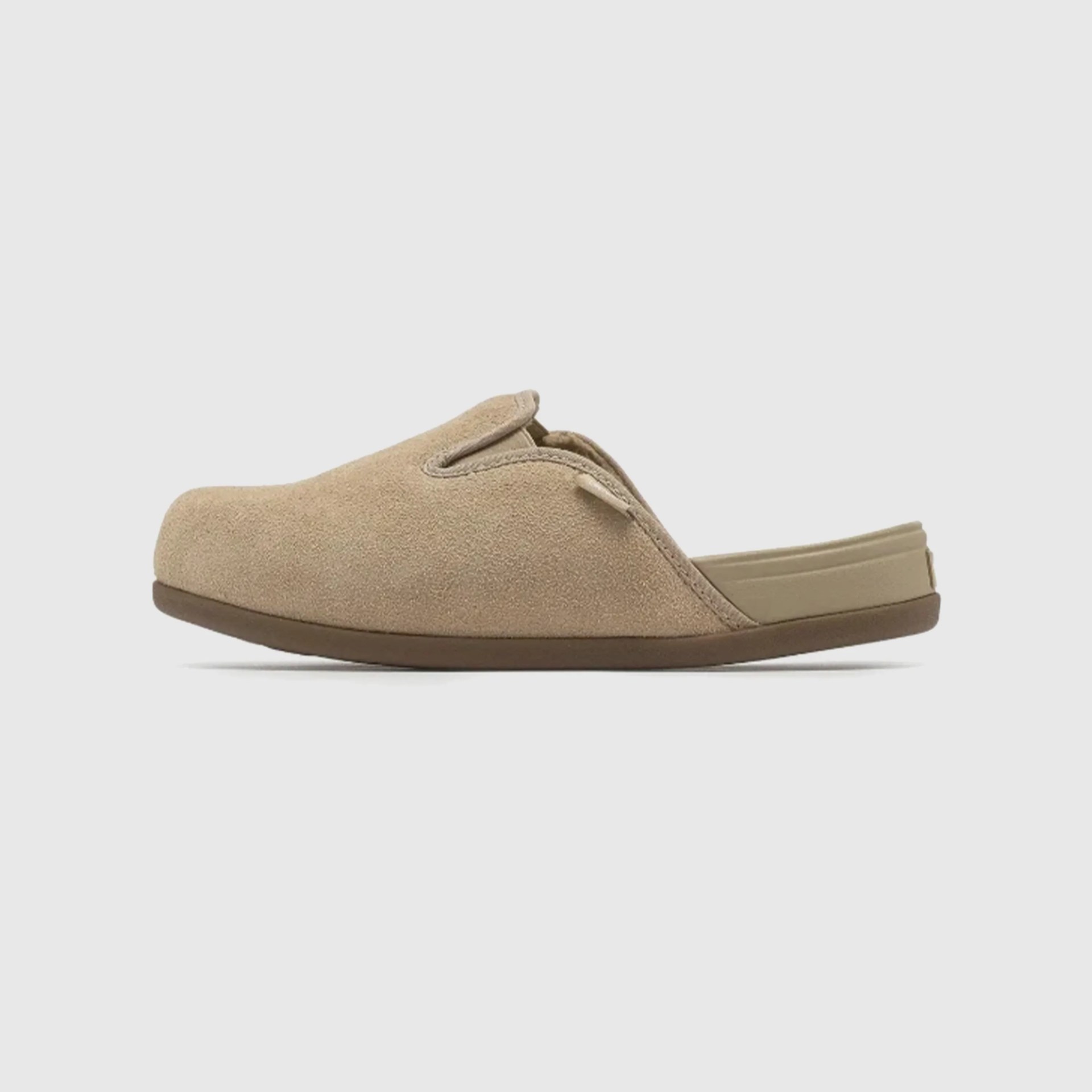 Beige suede slip-on slipper with a brown sole and open back.