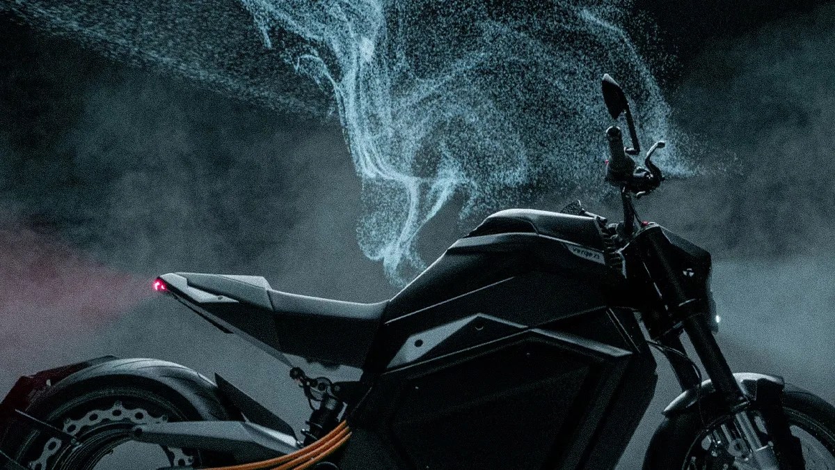 Black electric motorcycle with orange cables and blue smoke effect in the background.