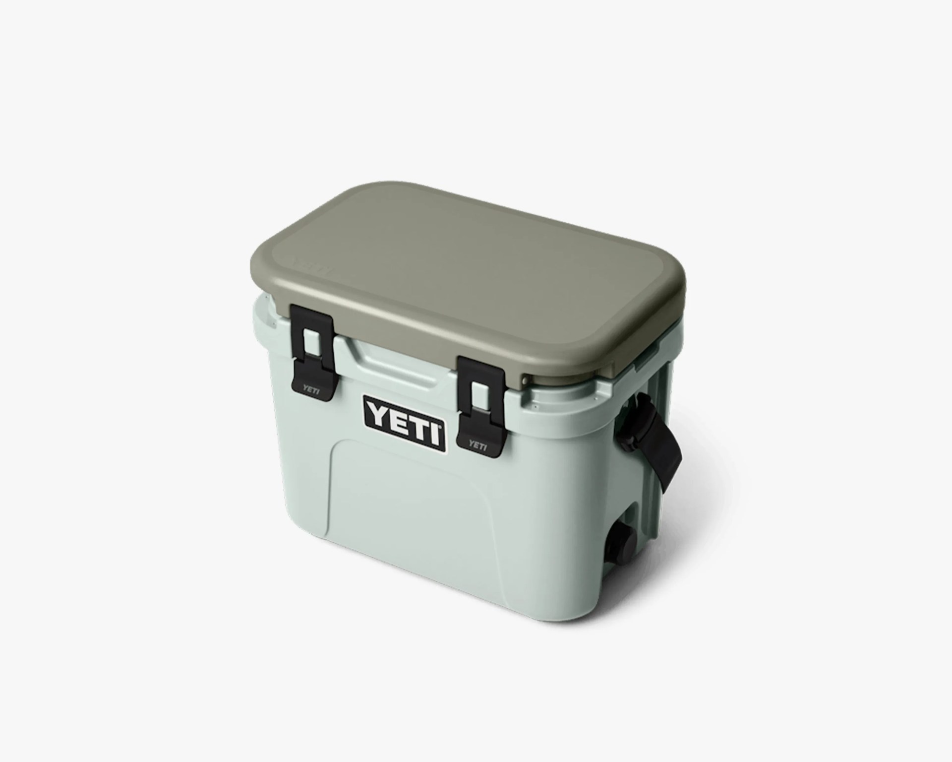 Light green YETI cooler with a gray lid and black latches on a white background.