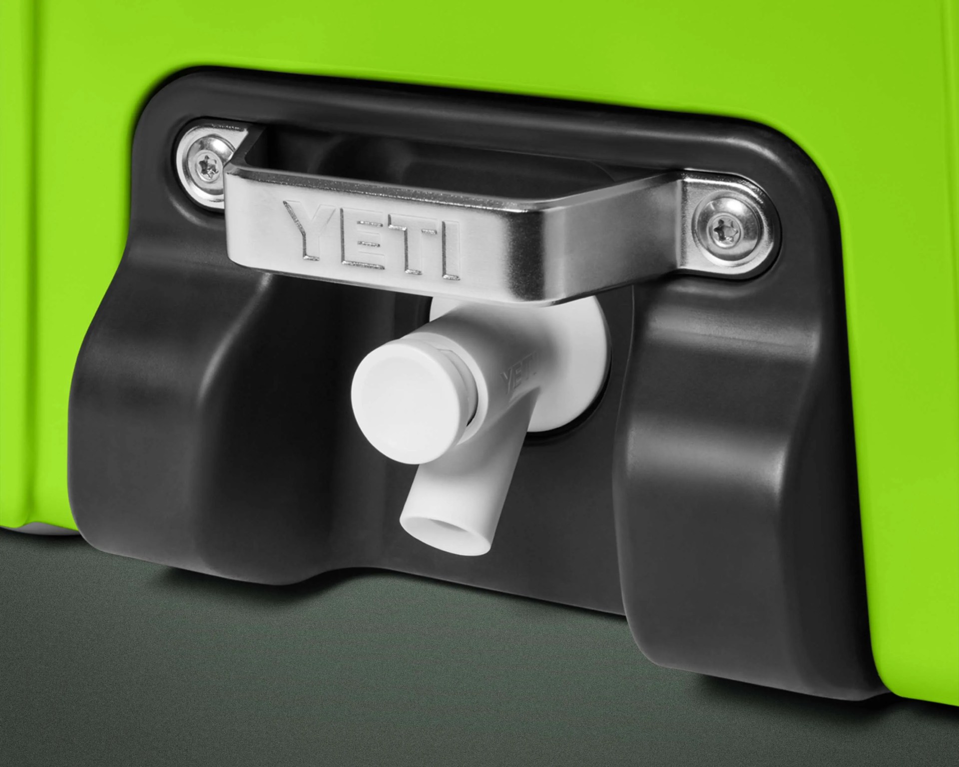 White plastic spout with silver YETI handle on a lime green cooler.