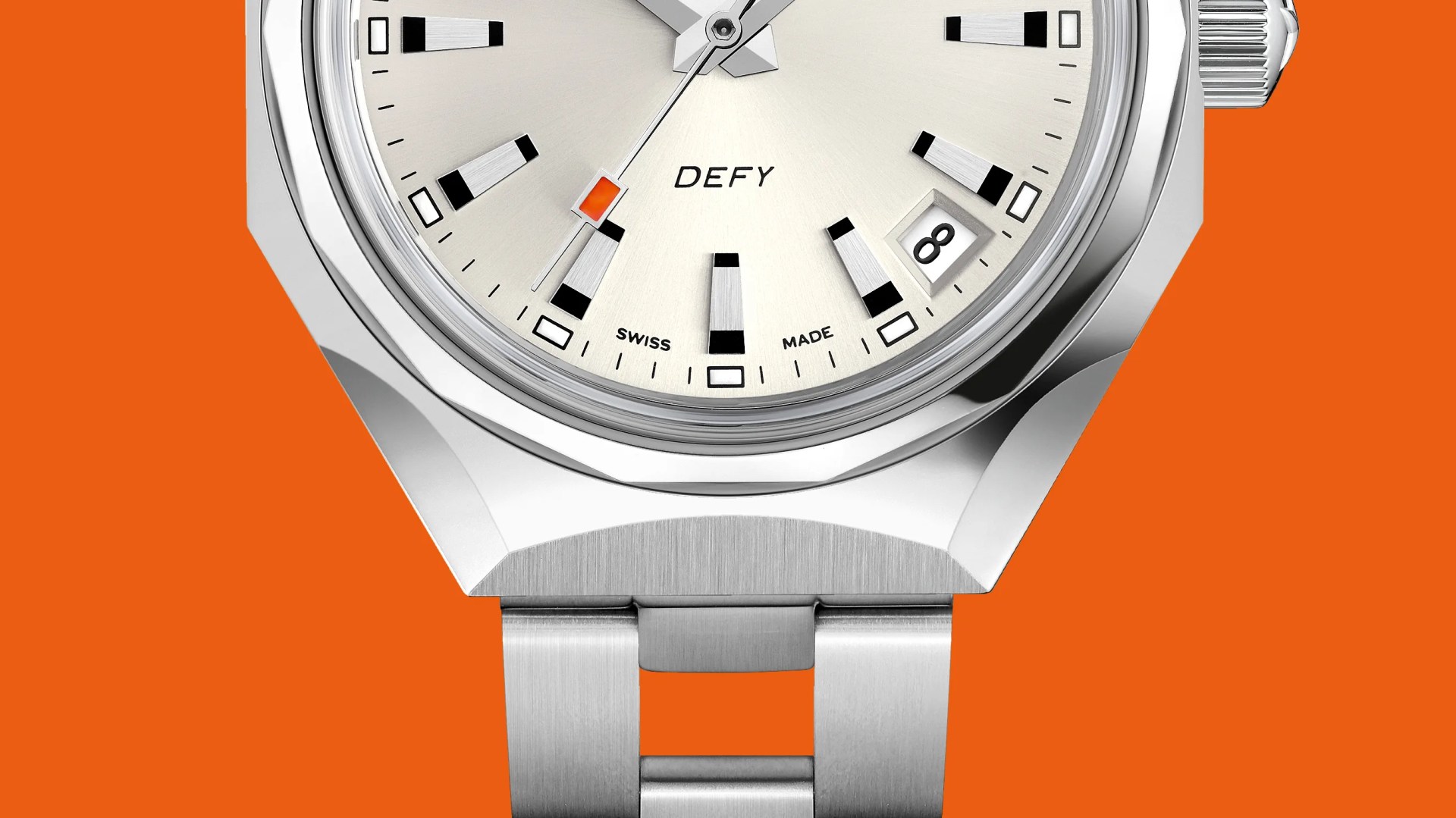 Close-up of a silver DEFY Swiss-made wristwatch with a date window and orange accent on the second hand against an orange background.