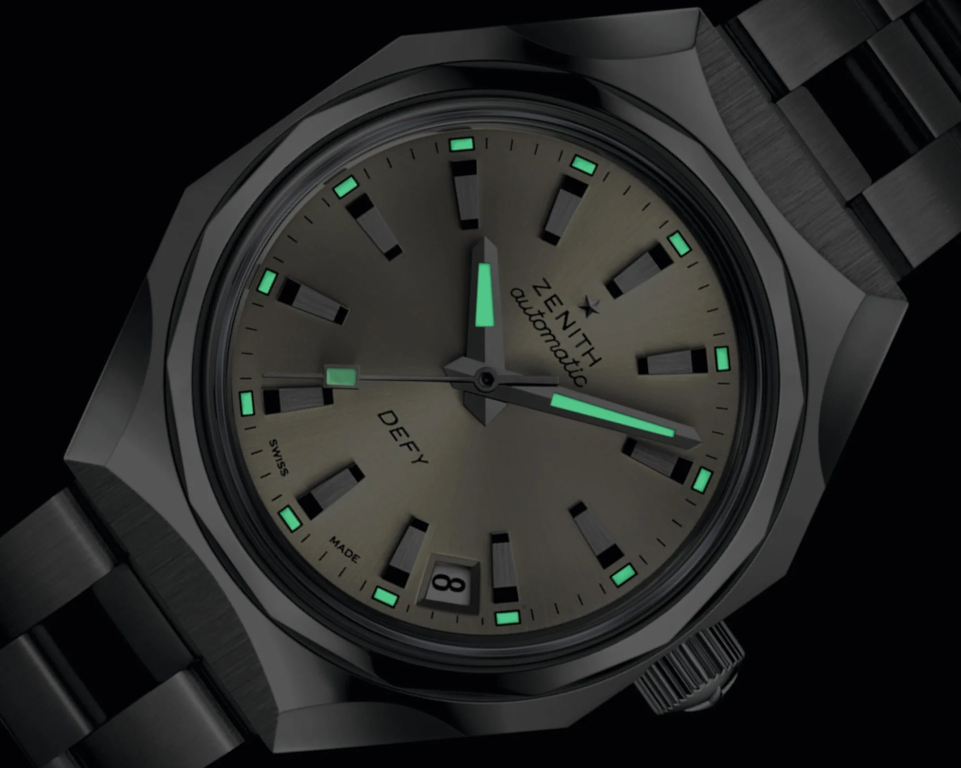 Black Zenith Defy automatic wristwatch with luminescent hands and hour markers on a dark dial.