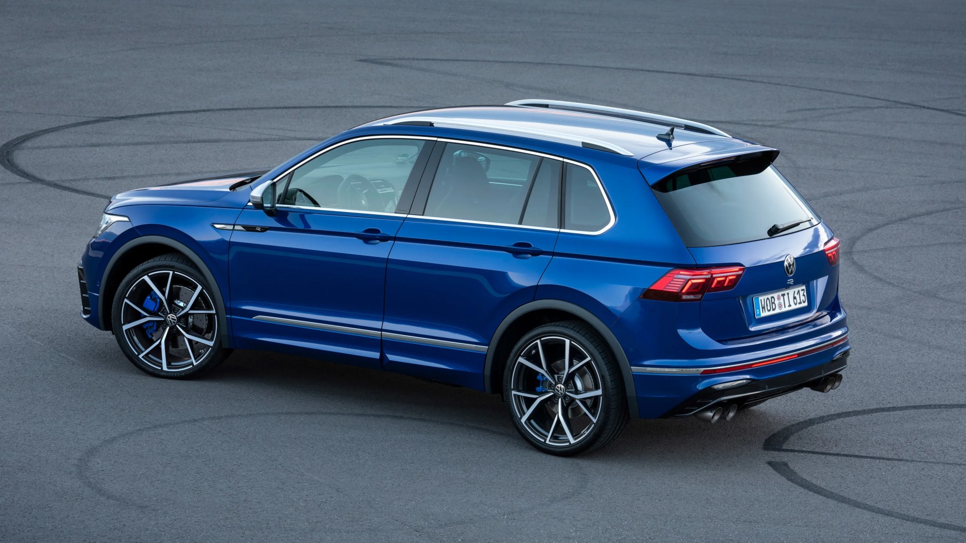 Blue Volkswagen Tiguan R SUV with black and silver alloy wheels on asphalt with tire marks.