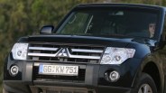 Front view of a black Mitsubishi SUV with European license plate GG KW 751 and a person visible inside.