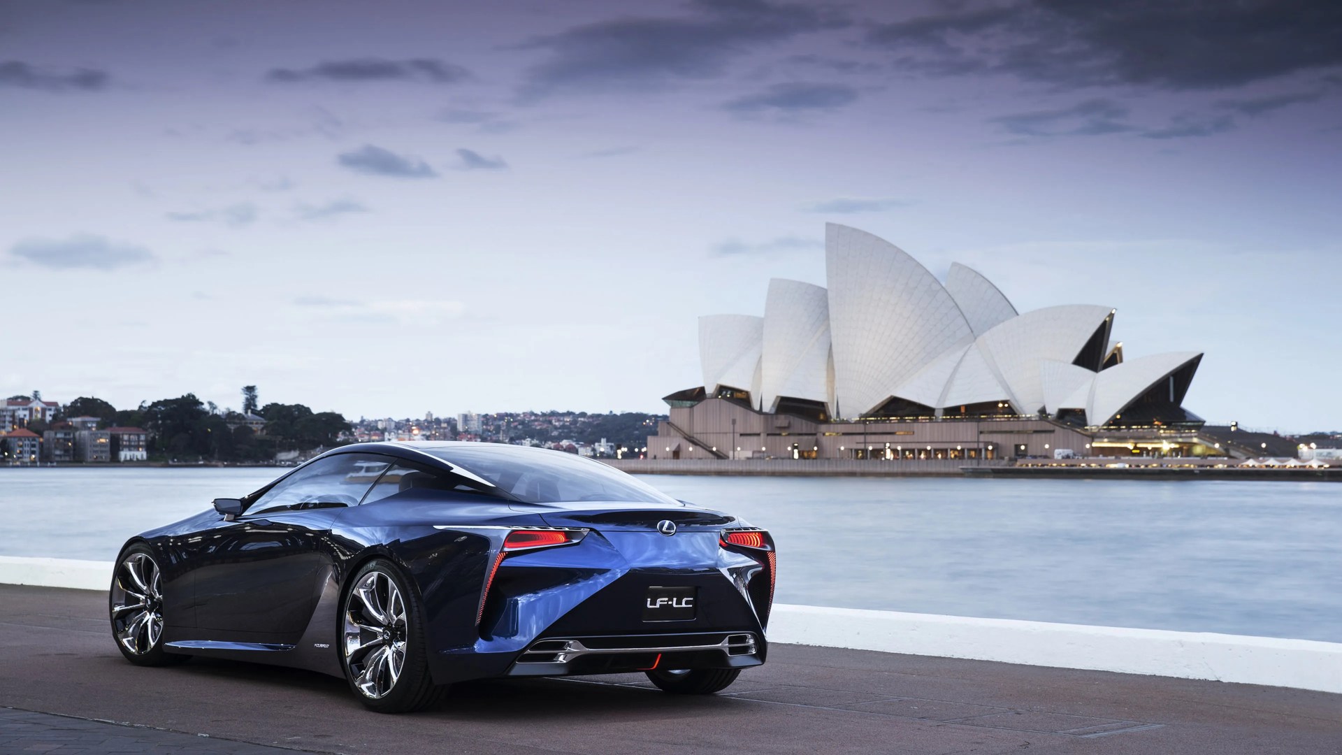 Dark blue Lexus LF-LC concept car parked near water with Sydney Opera House in the background.