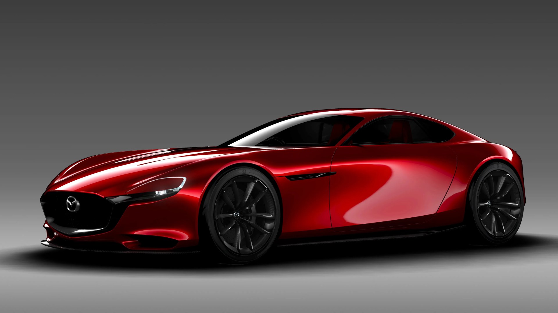 Sleek red Mazda sports car with black wheels and tinted windows on a gray gradient background.