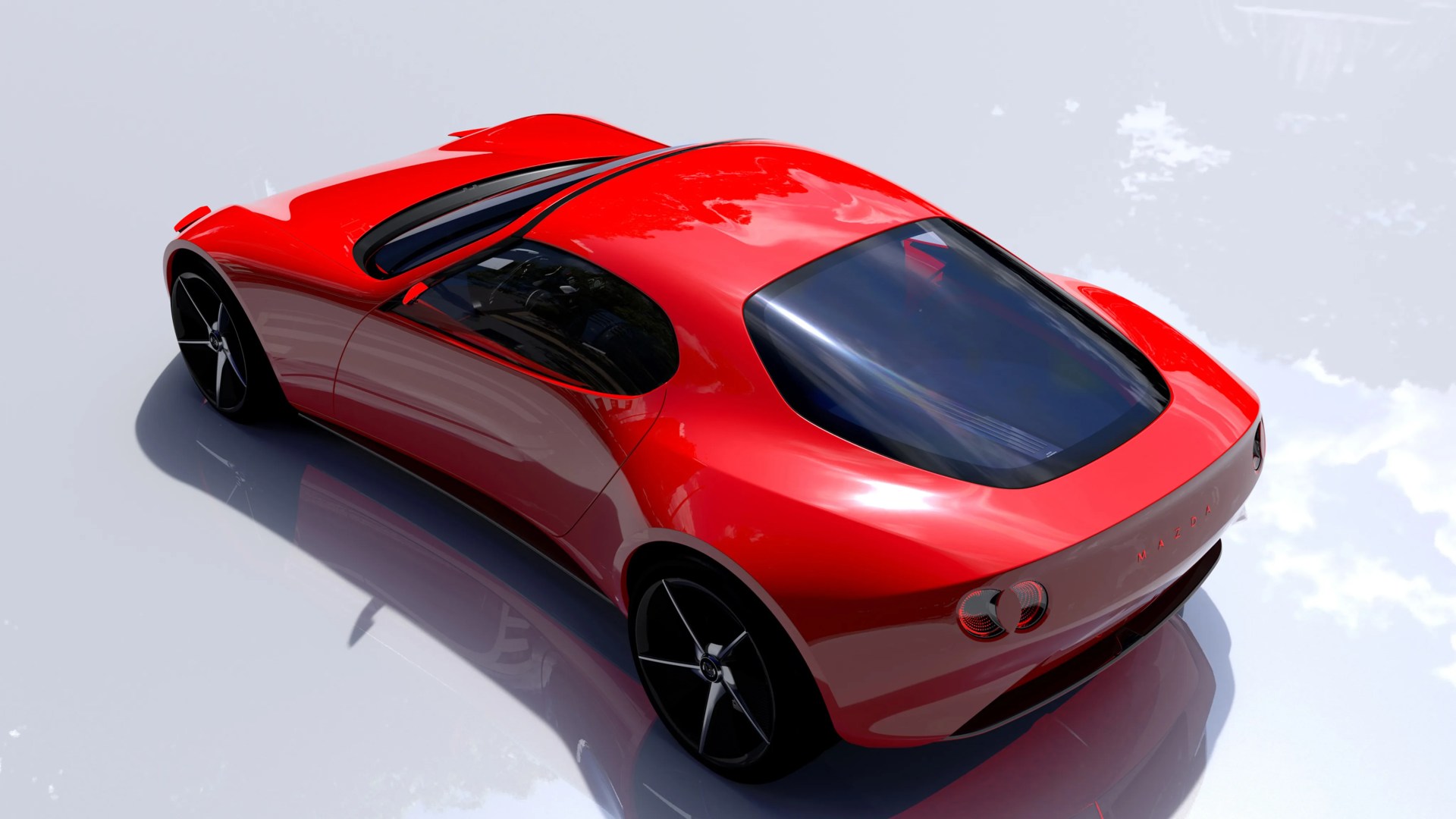 Glossy red Mazda sports car with large black wheels and tinted rear window on reflective surface.