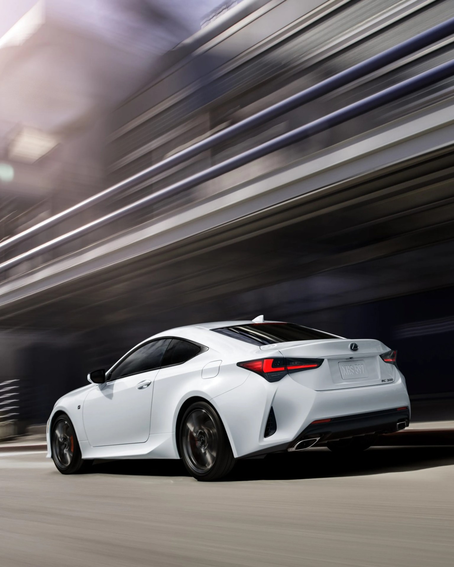 White Lexus RC 300 coupe with tinted windows driving on a city street with blurred background.